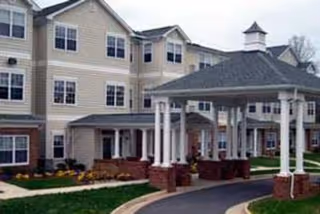Exterior view of Oaks of Wellington senior living building with covered entrance.