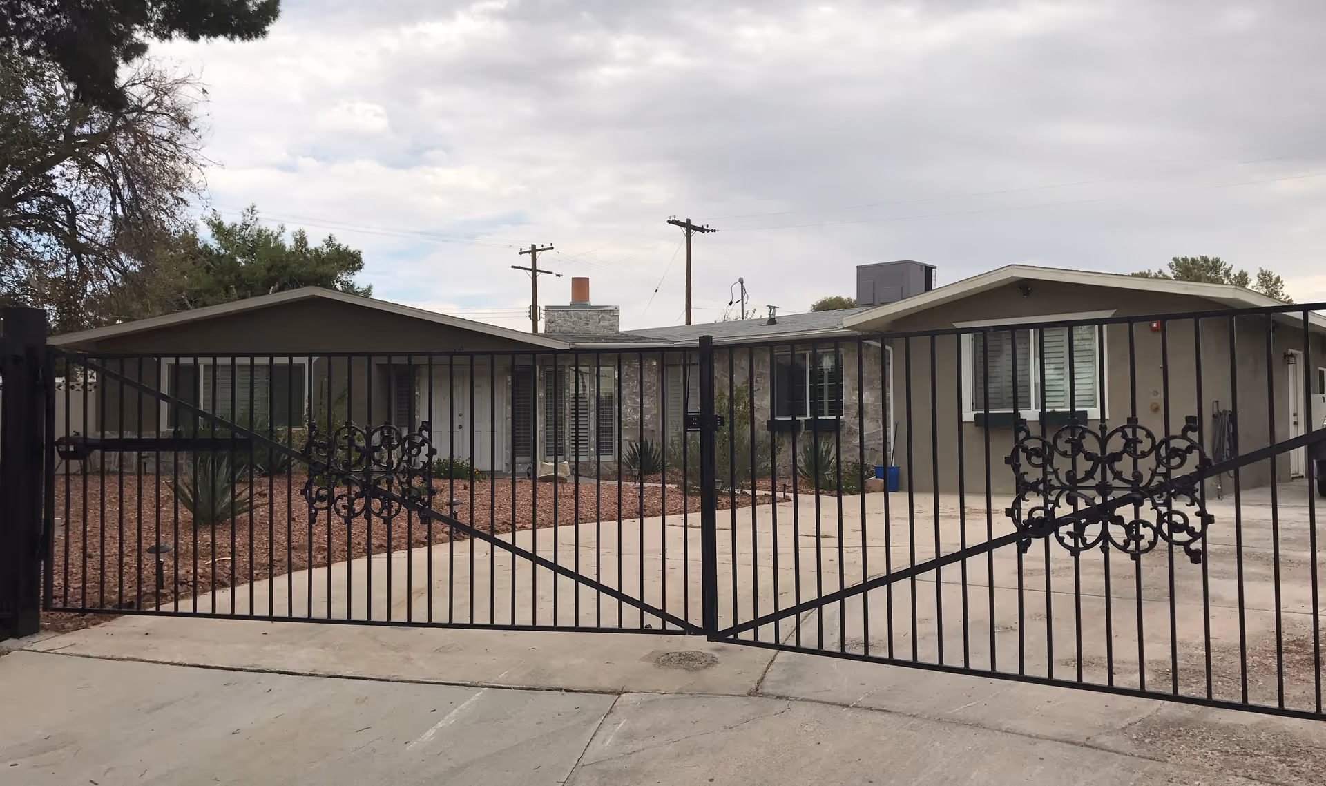 Gated entrance leads to Johnny Angels Care Home, a single-story building with desert landscaping.