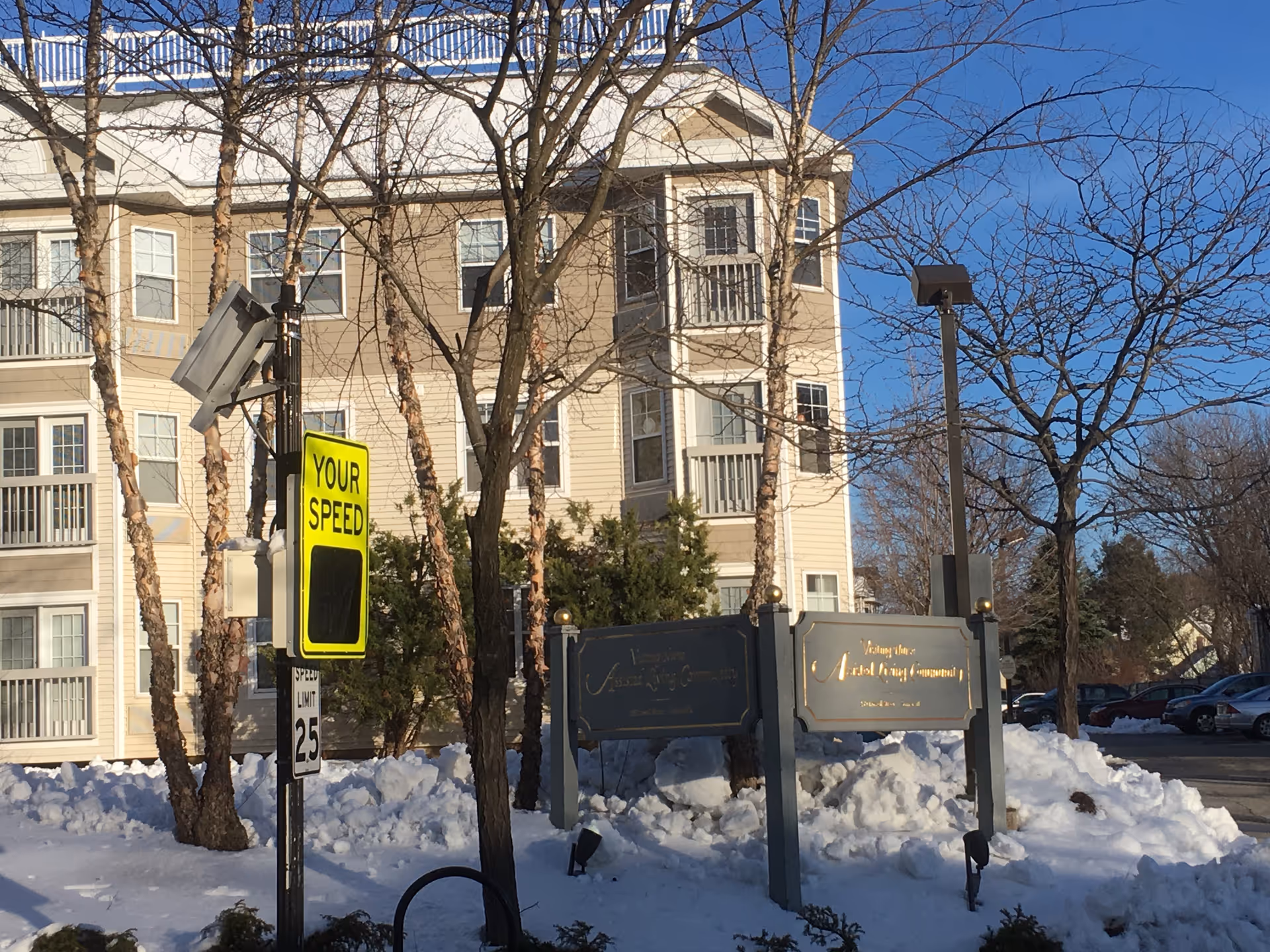 Exterior view of VNA of Eastern Massachusetts building with snow, leafless trees, and foreground signs.