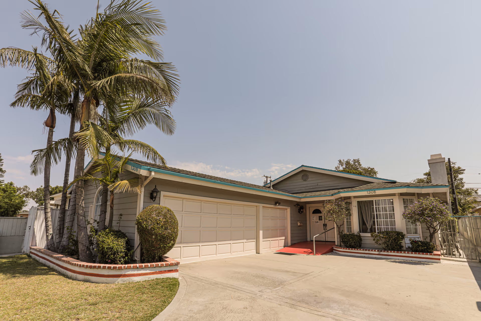 Exterior view of Summerwind Manor Inc., single-story senior living facility, with a two-car garage and palms.