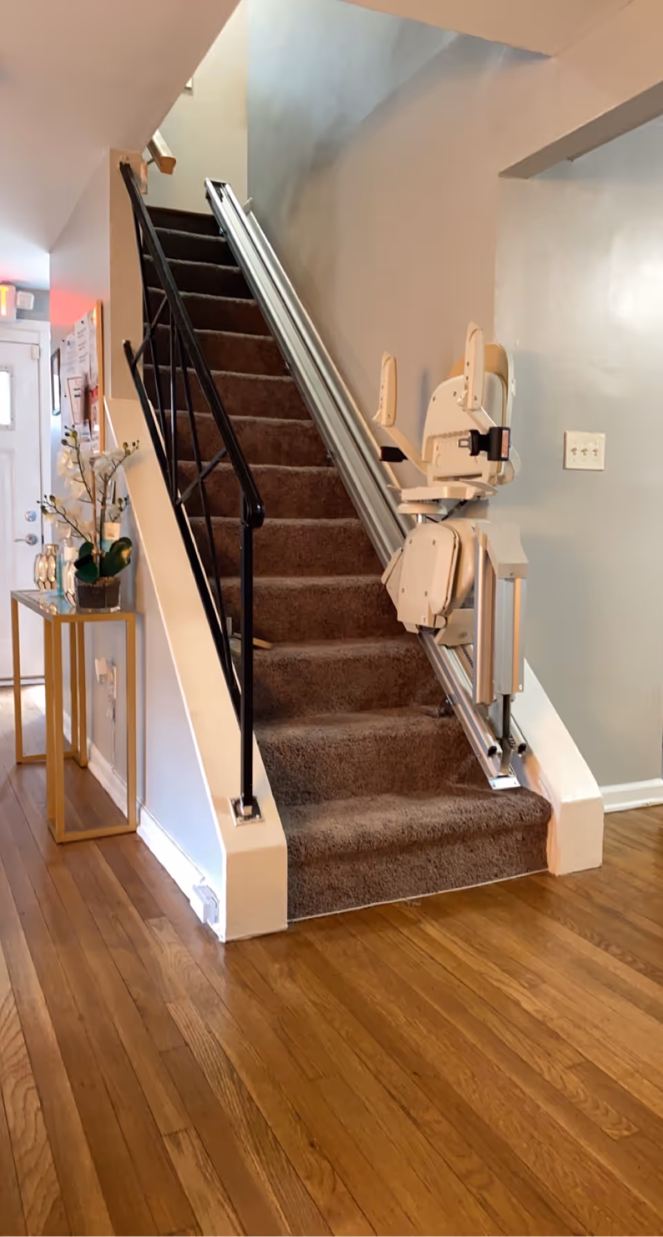 Interior hallway featuring a stairlift attached to carpeted stairs.