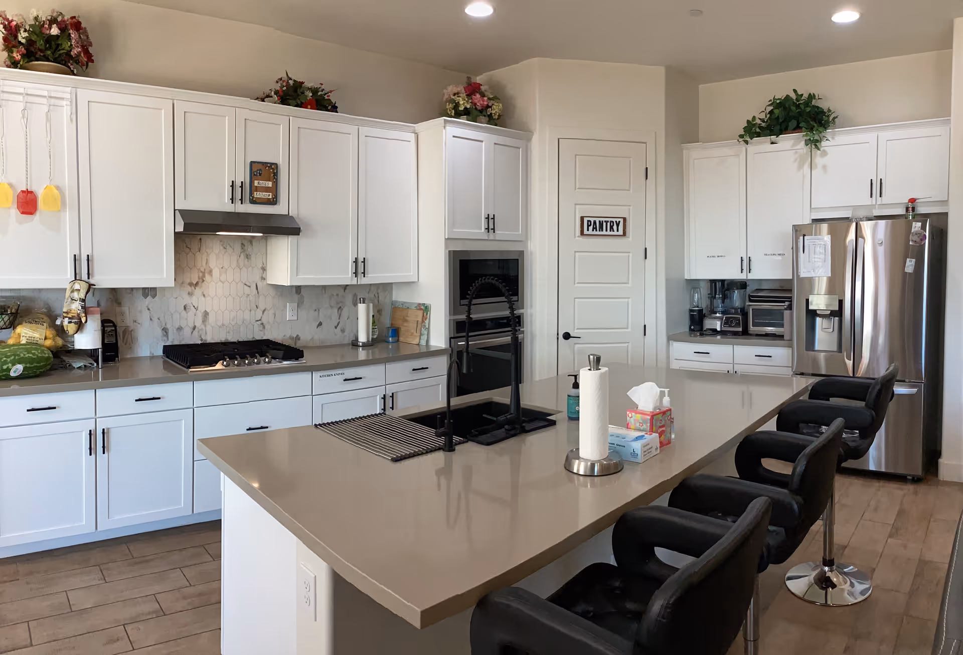 Bright, modern kitchen with island, white cabinets, and stainless steel appliances.