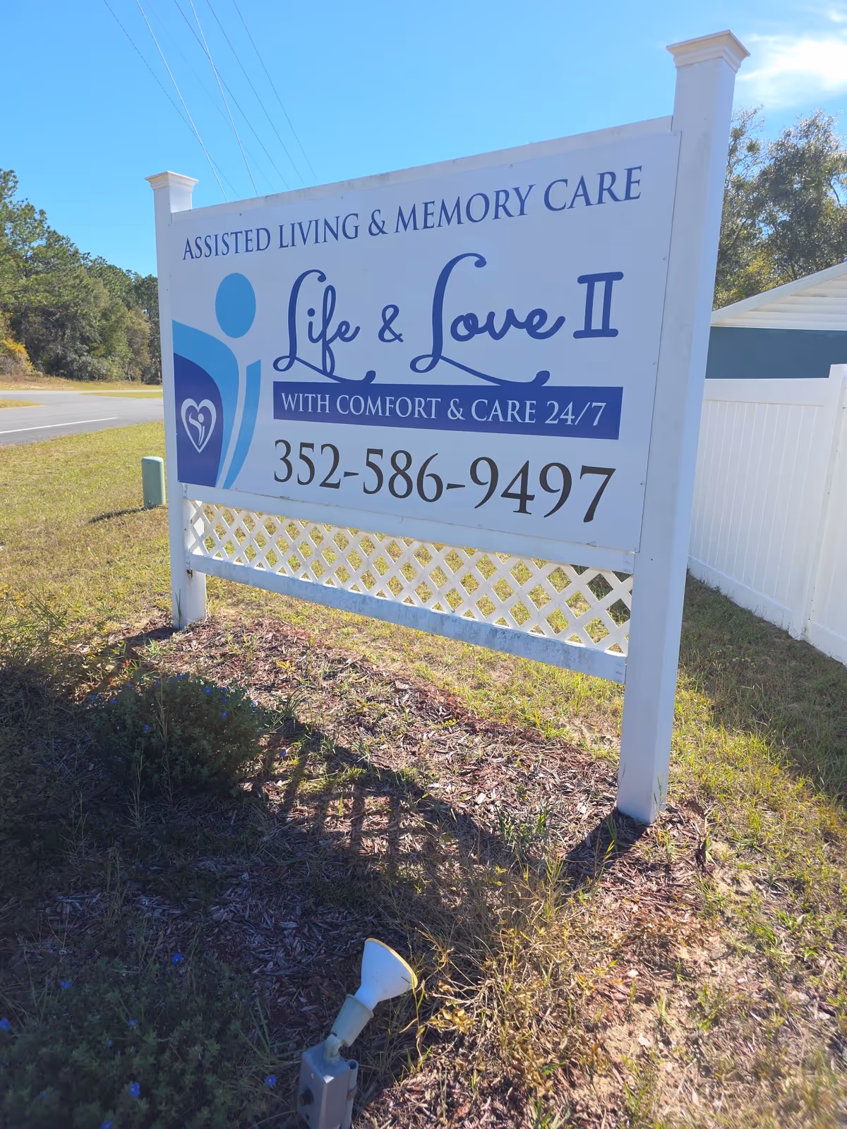 Large white roadside sign advertising Life & Love II assisted living and memory care services.