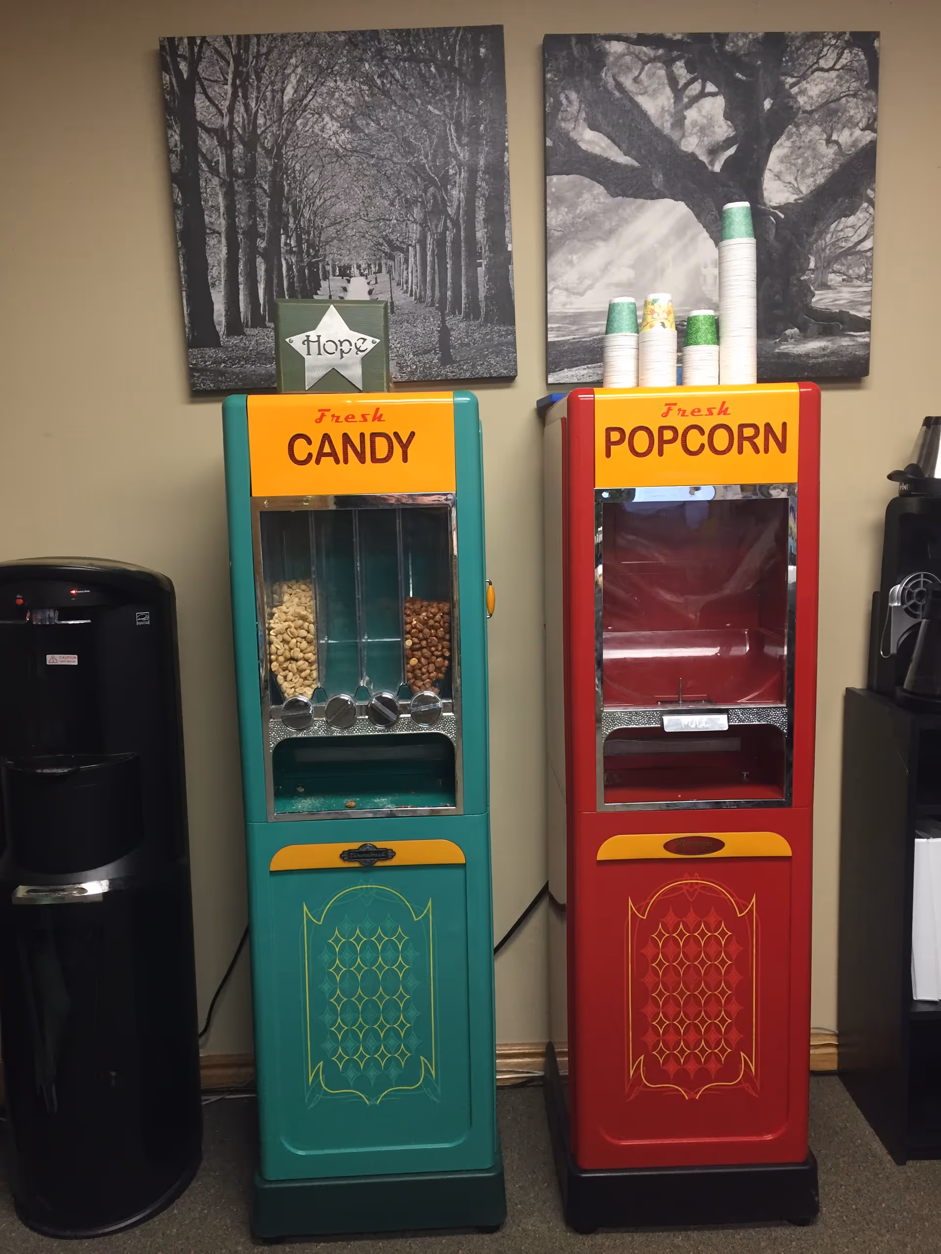 Colorful candy and popcorn vending machines in a senior living facility hallway.