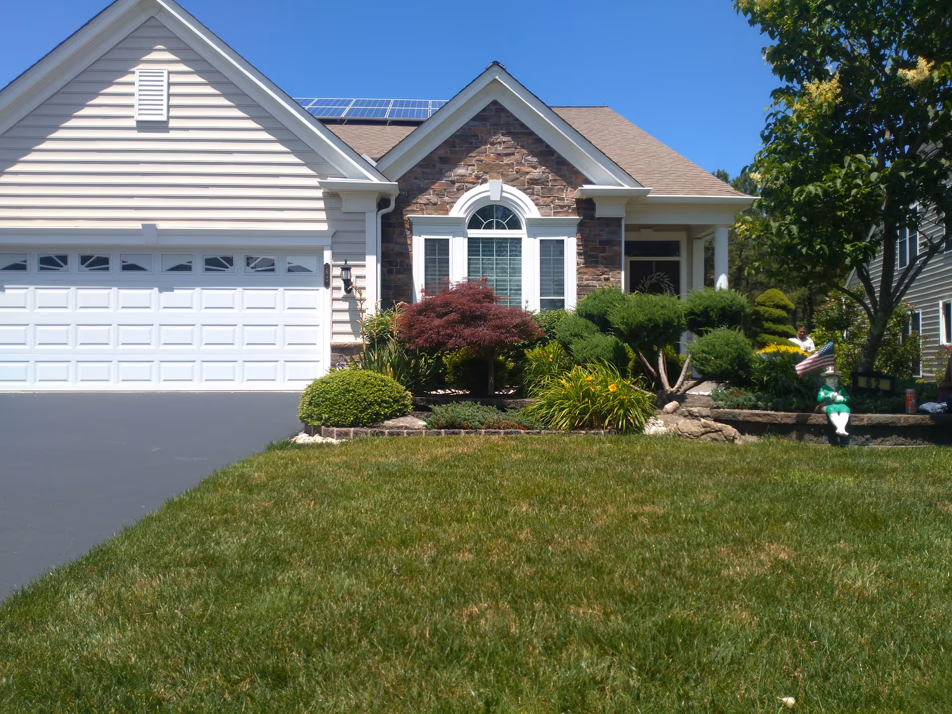Front exterior of River Pointe facility with landscaped yard and two-car garage.