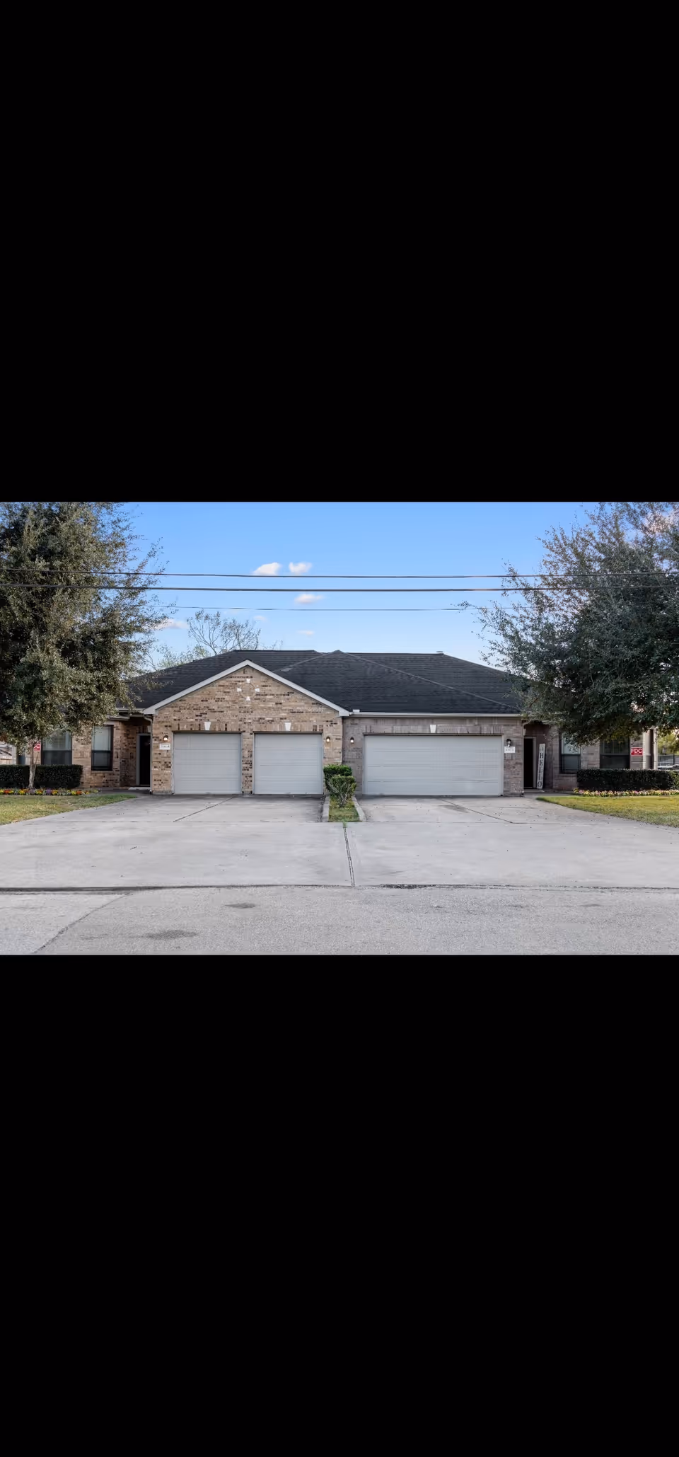 Front view of Treasure Tower Assisted Living building with three garages and driveway.