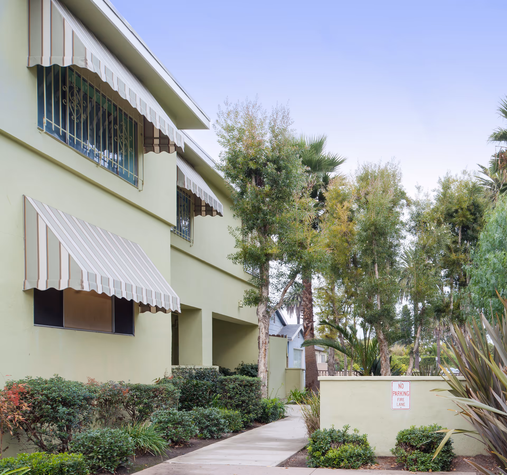 Exterior view of Meadowbrook Behavioral Health Center with striped awnings and manicured landscaping.