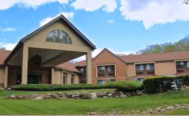 Promenade at Chestnut Ridge: a senior living facility front entrance with brick exterior and landscaped lawn.