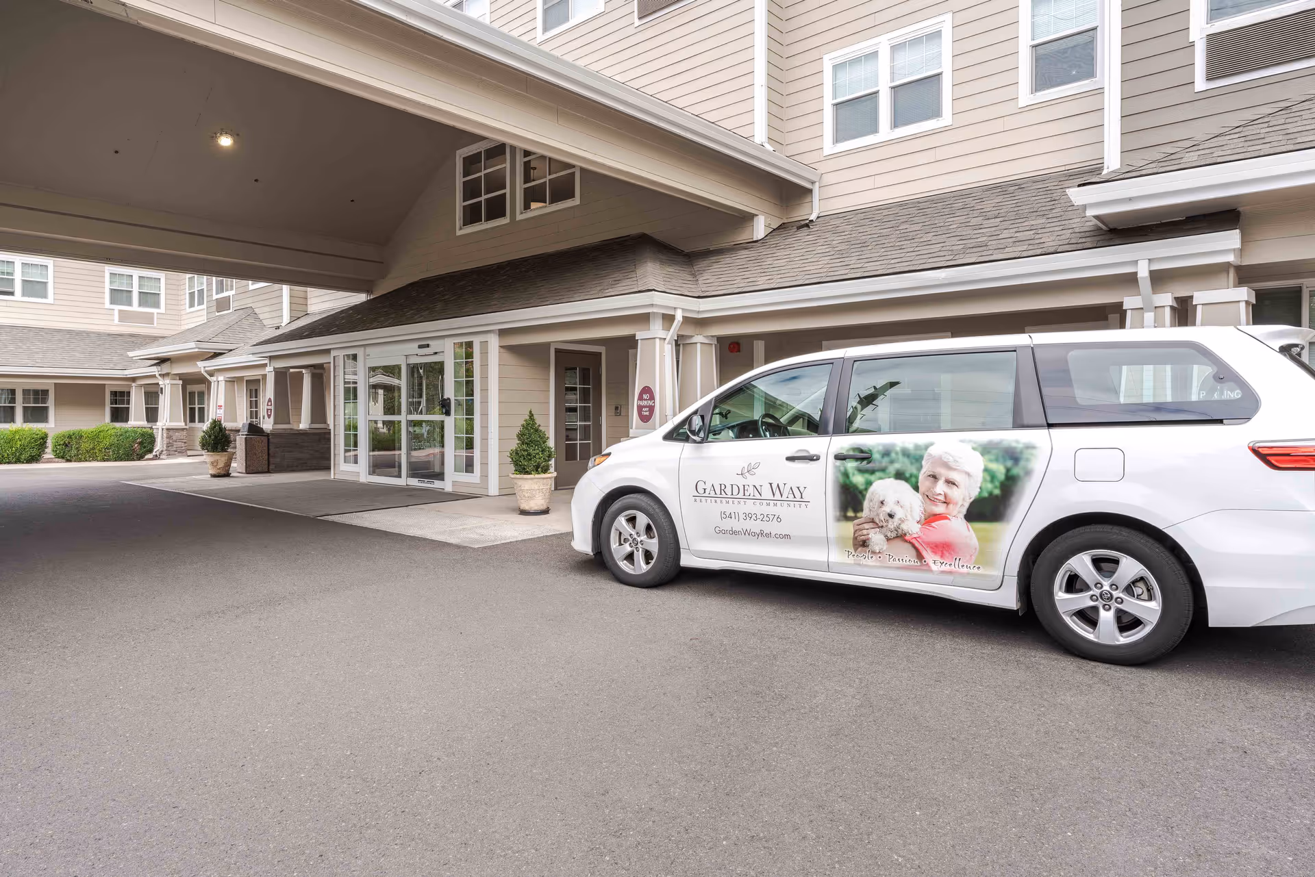 Exterior view of Garden Way Retirement Community entrance with a branded white van parked in front.