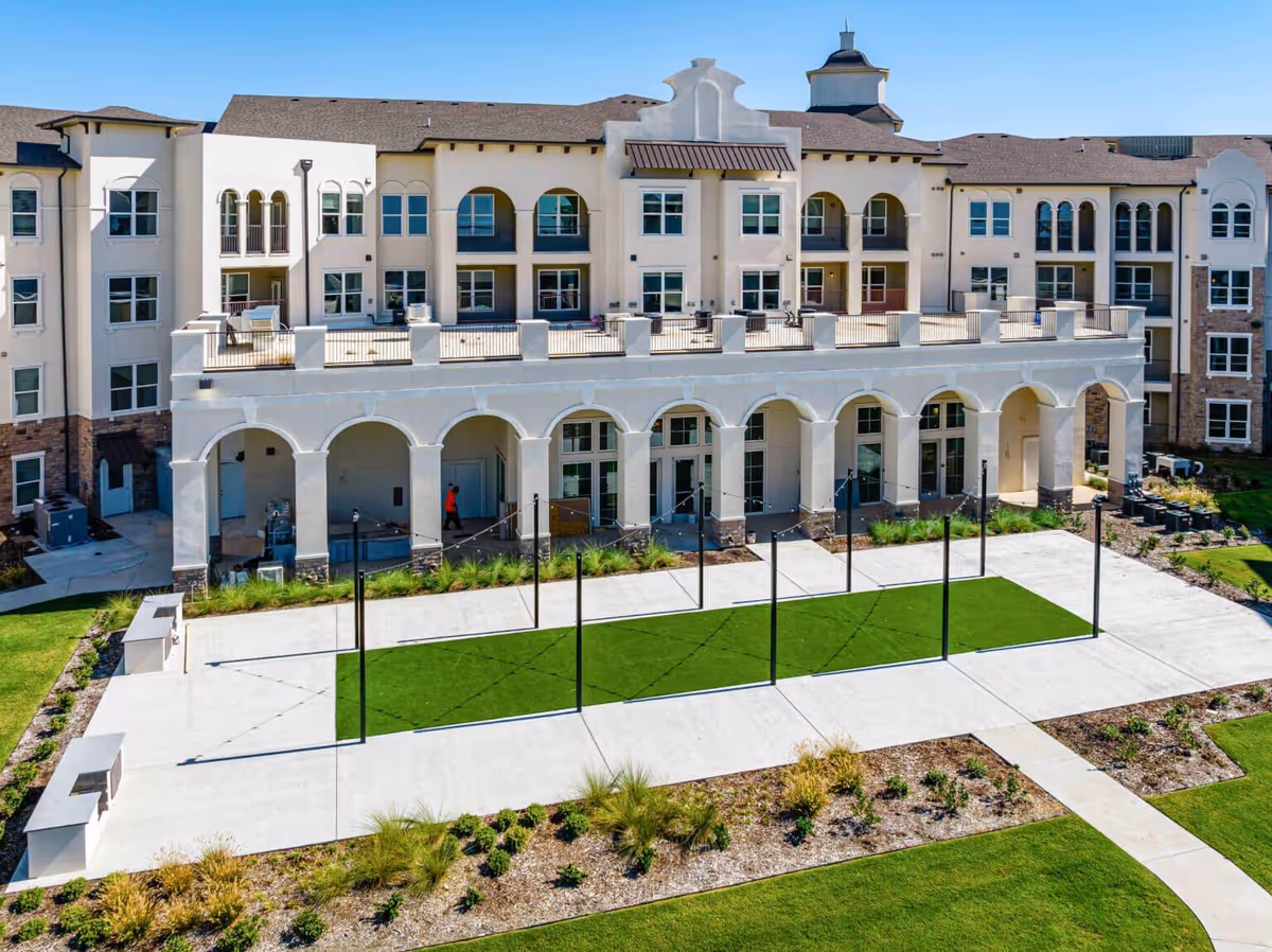 Exterior view of a Wilshire Senior Living building with arches and a landscaped courtyard.