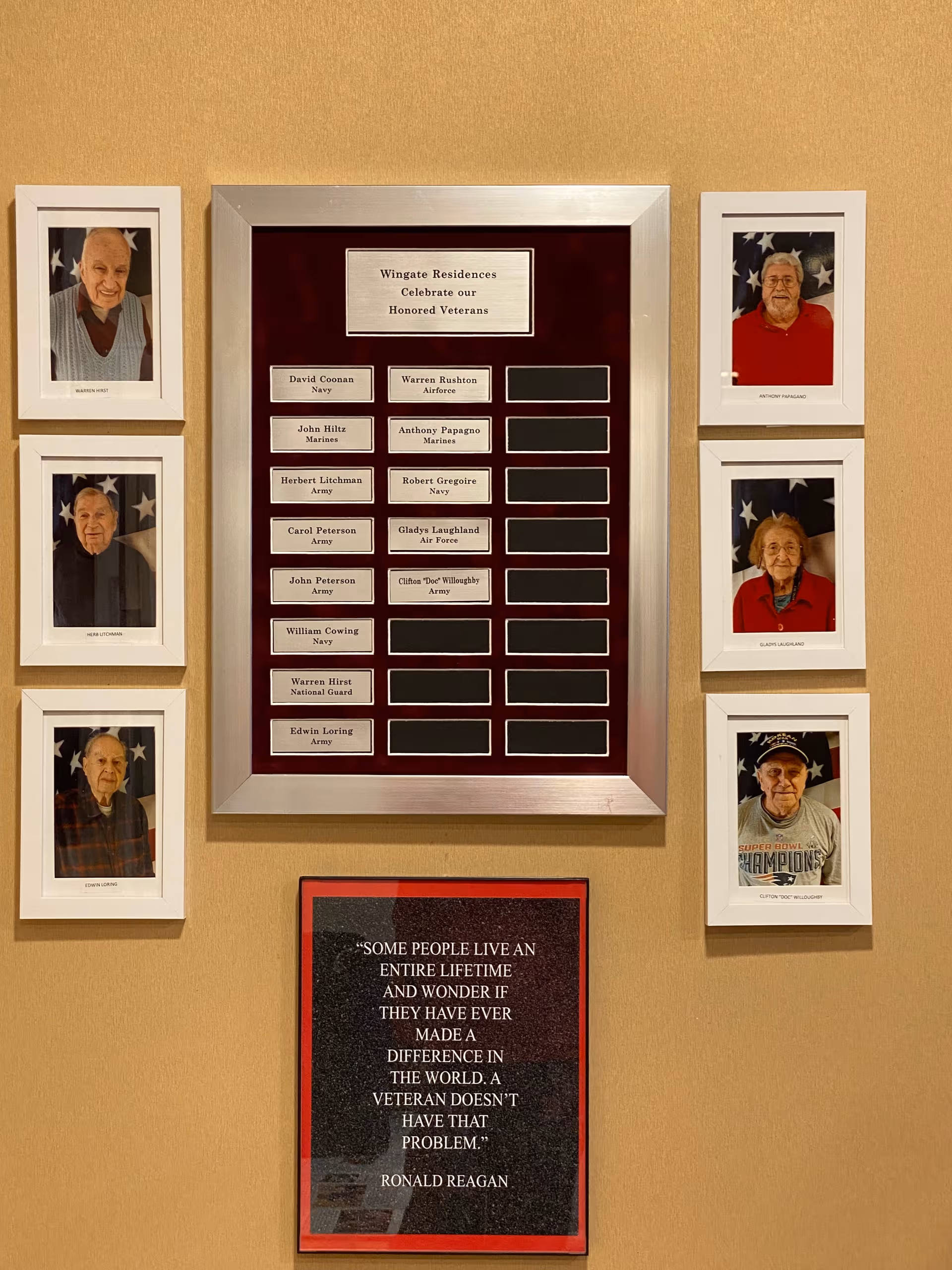 Interior wall display honors veterans with framed portraits surrounding a central Wingate plaque.