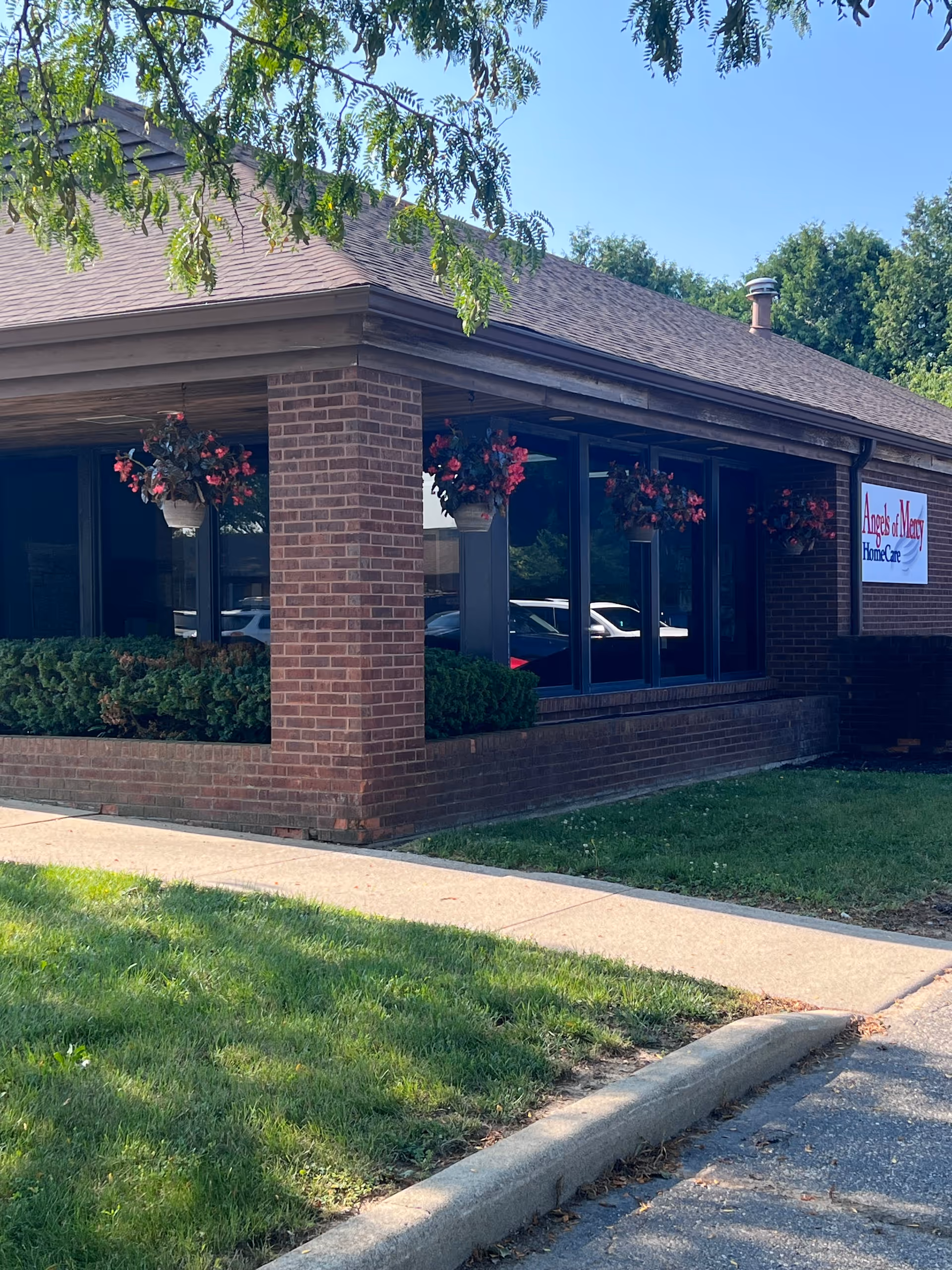Exterior view of Angels of Mercy HomeCare building with brick walls and hanging baskets.