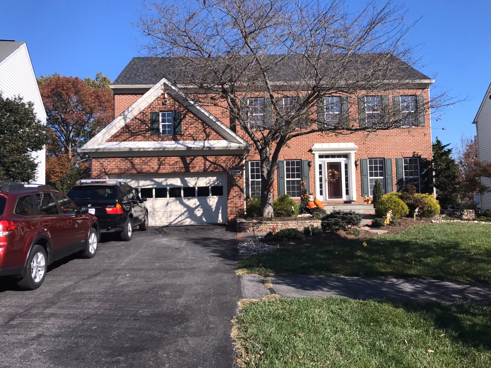 Brick two-story building with a garage, driveway, and landscaped front yard.