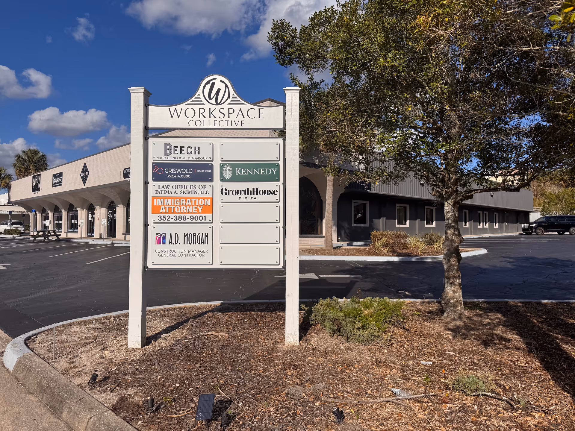 Exterior view of a storefront with a tall tenant signboard, including Griswold Home Care.