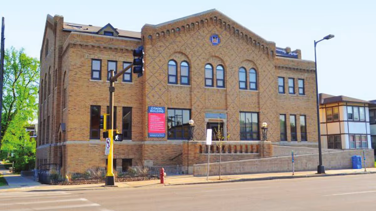 Brick building with arched windows on a street corner facade