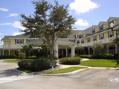 Arbor Oaks at Greenacres building exterior with covered entrance and manicured landscaping.