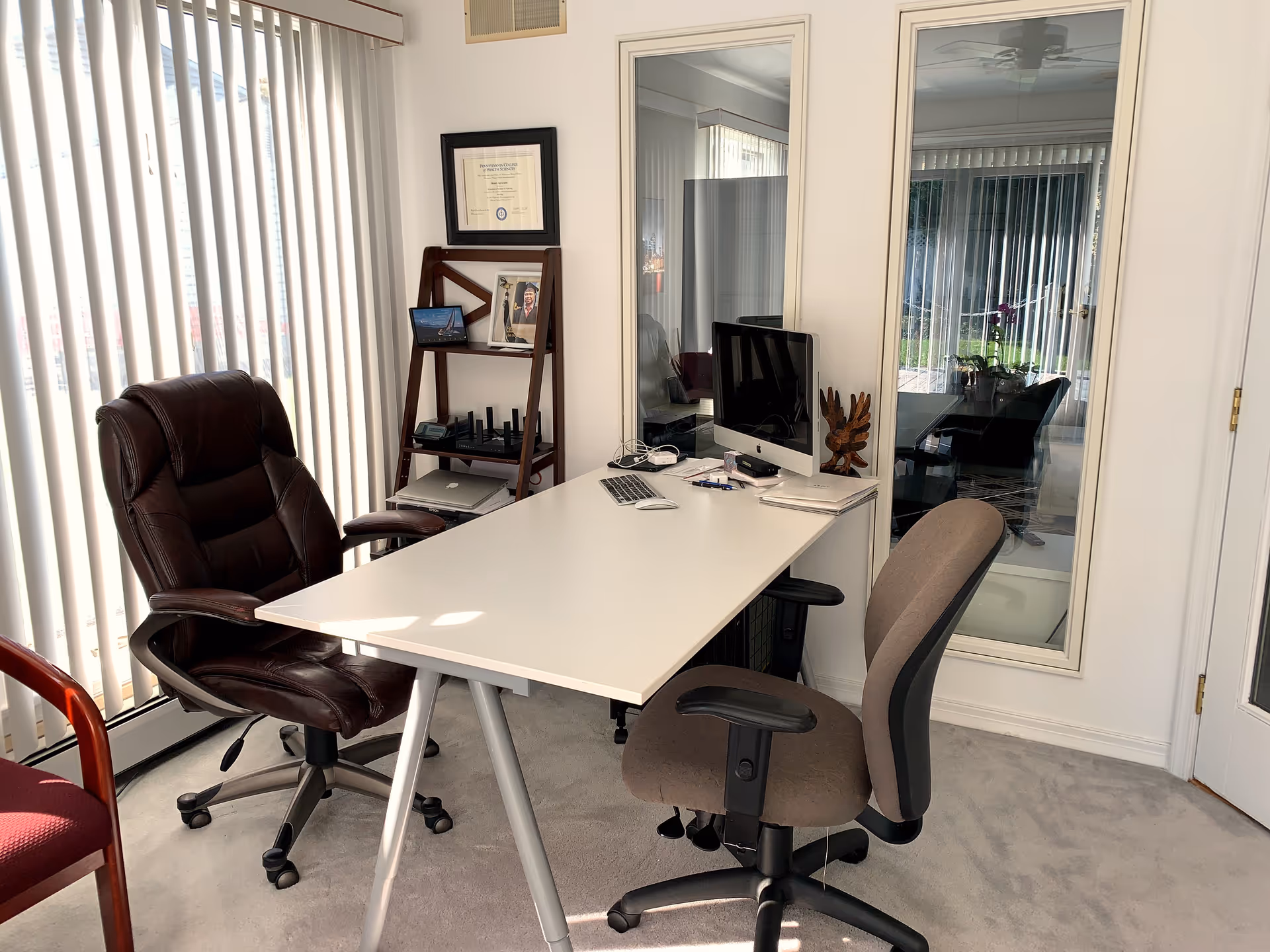 Modern office space inside a senior living facility with a desk, two chairs, and a computer.