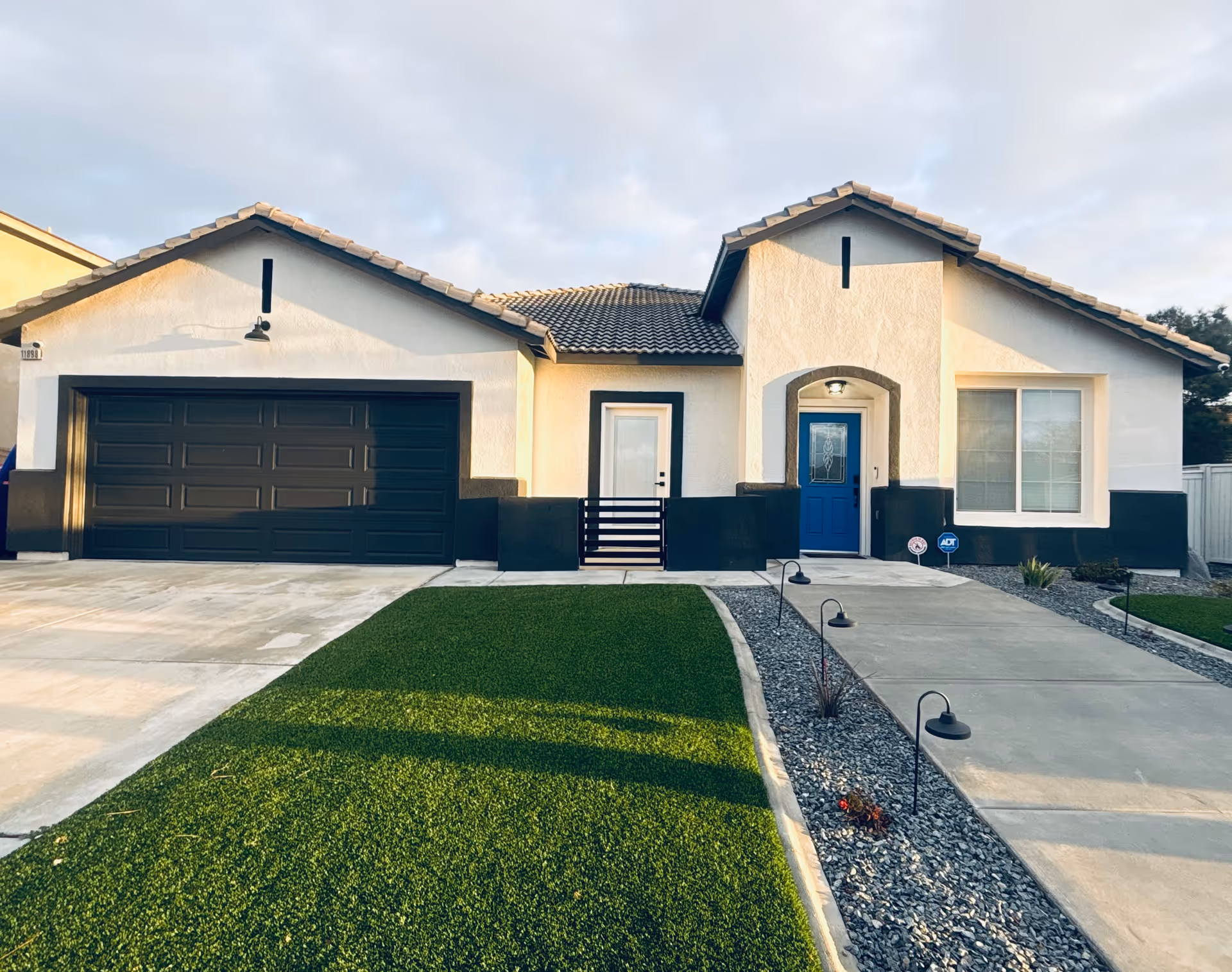 Front exterior of a single-story building with a blue door and garage.