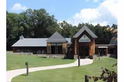 Front view of New Windsor Country Inn with stone entrance and green lawn.