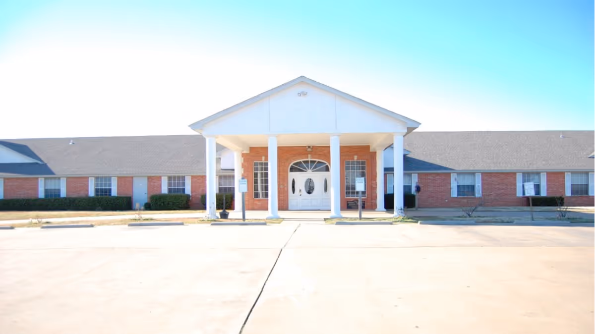 Exterior view of Calera Manor Nursing Home with brick facade and front entrance.