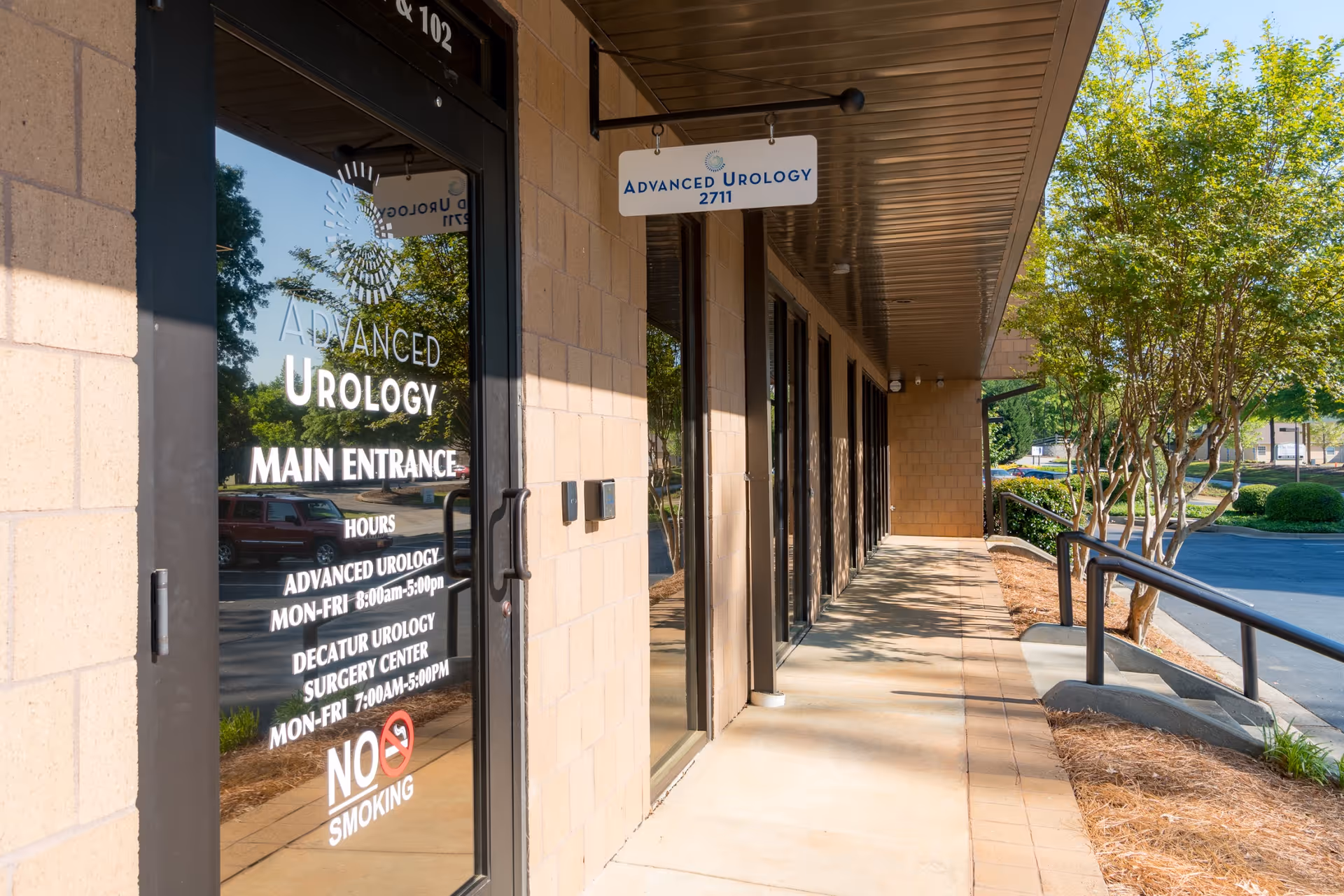 Exterior view of Advanced Urology building entrance with glass doors and signage.