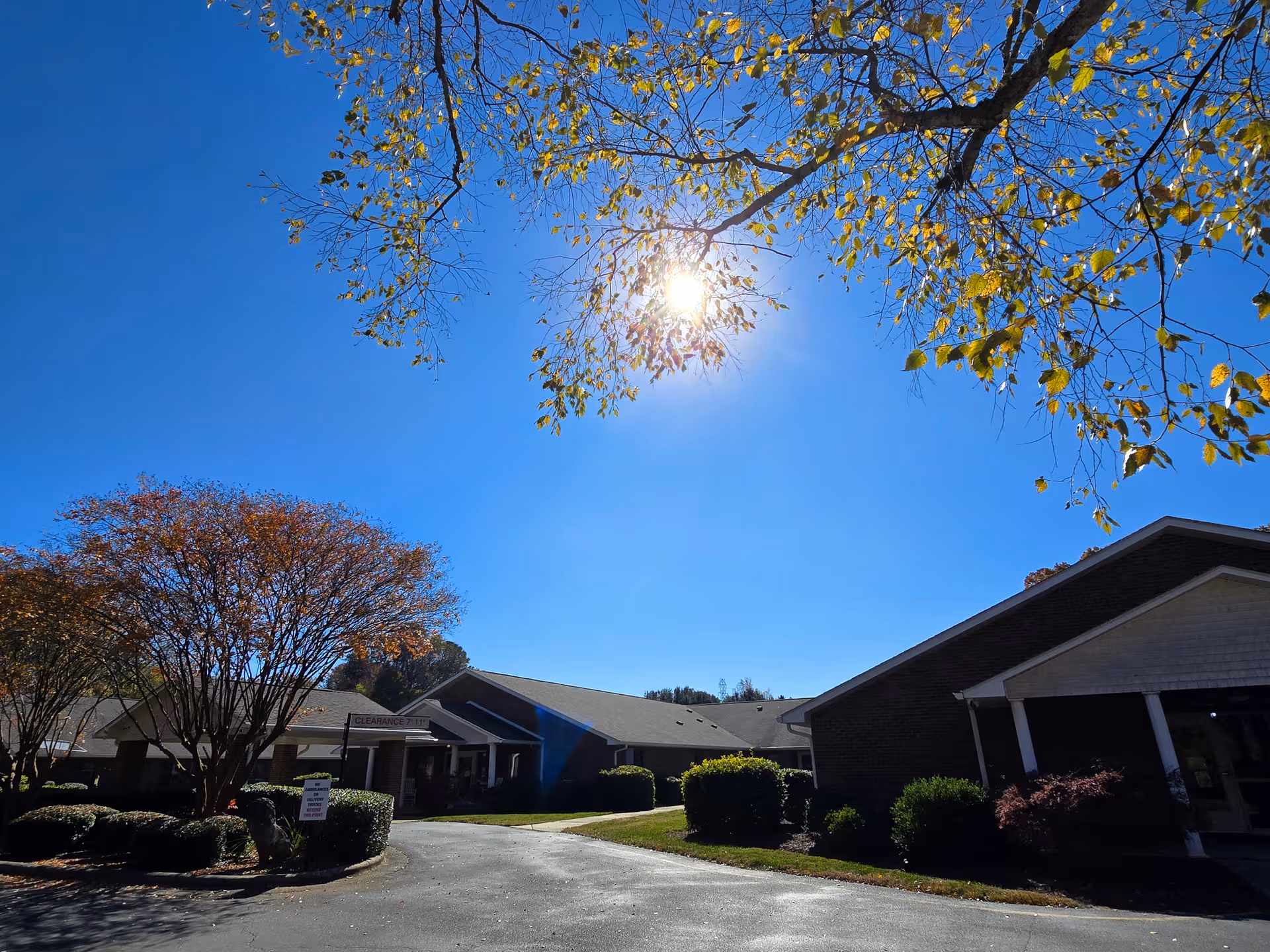 Sunny day view of Peak Resources Brookshire exterior with driveway and landscaped entrance.