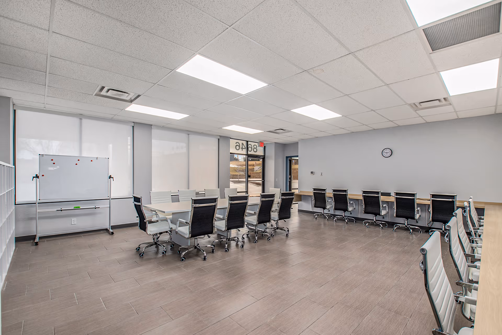 Bright interior conference room with long table, whiteboard, and multiple chairs.