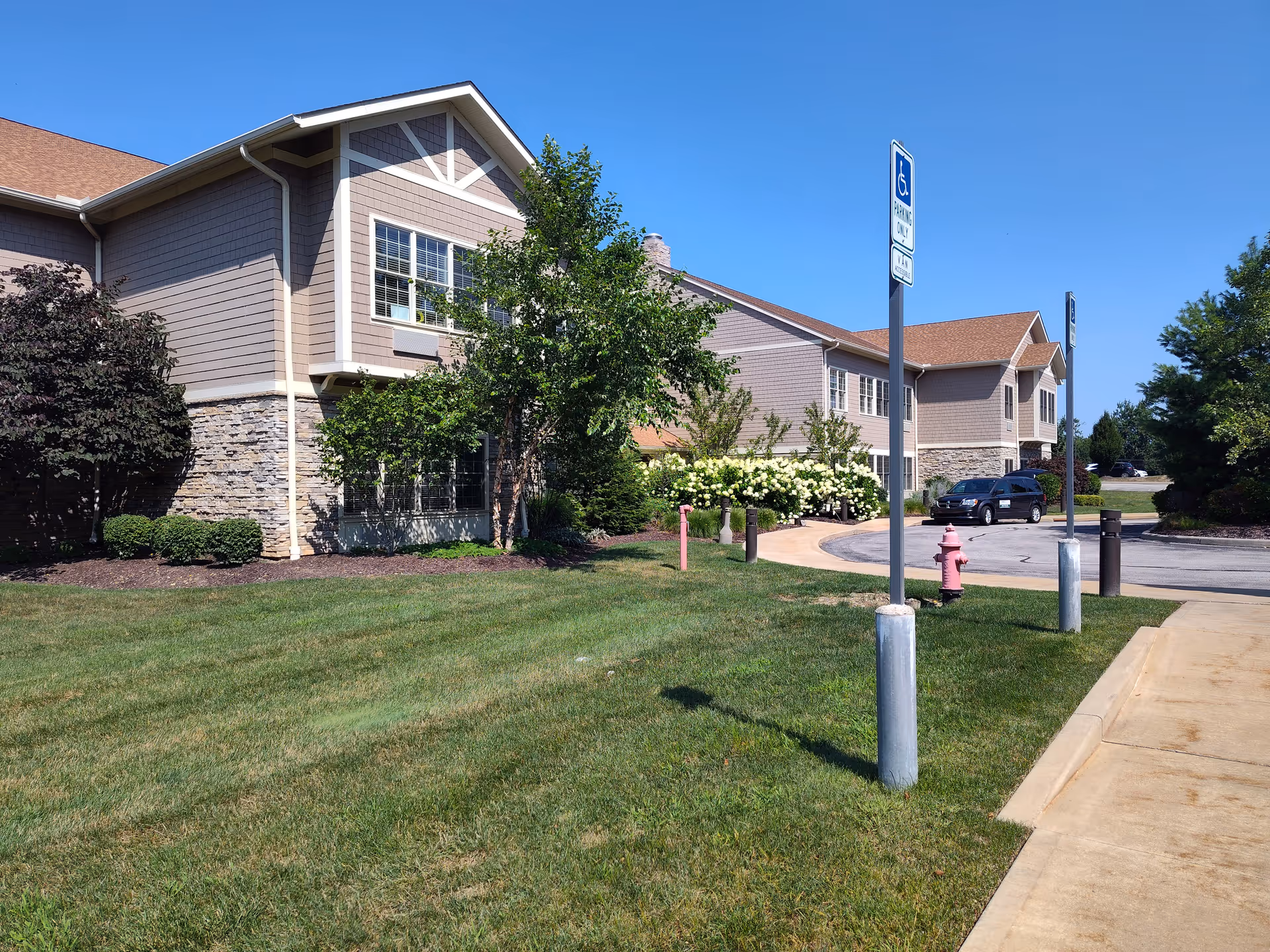 Exterior view shows Shurmer Place senior living facility with manicured lawn and parking.