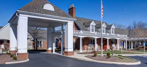 Exterior view of Brookdale Englewood entrance with porte-cochère and flagpole