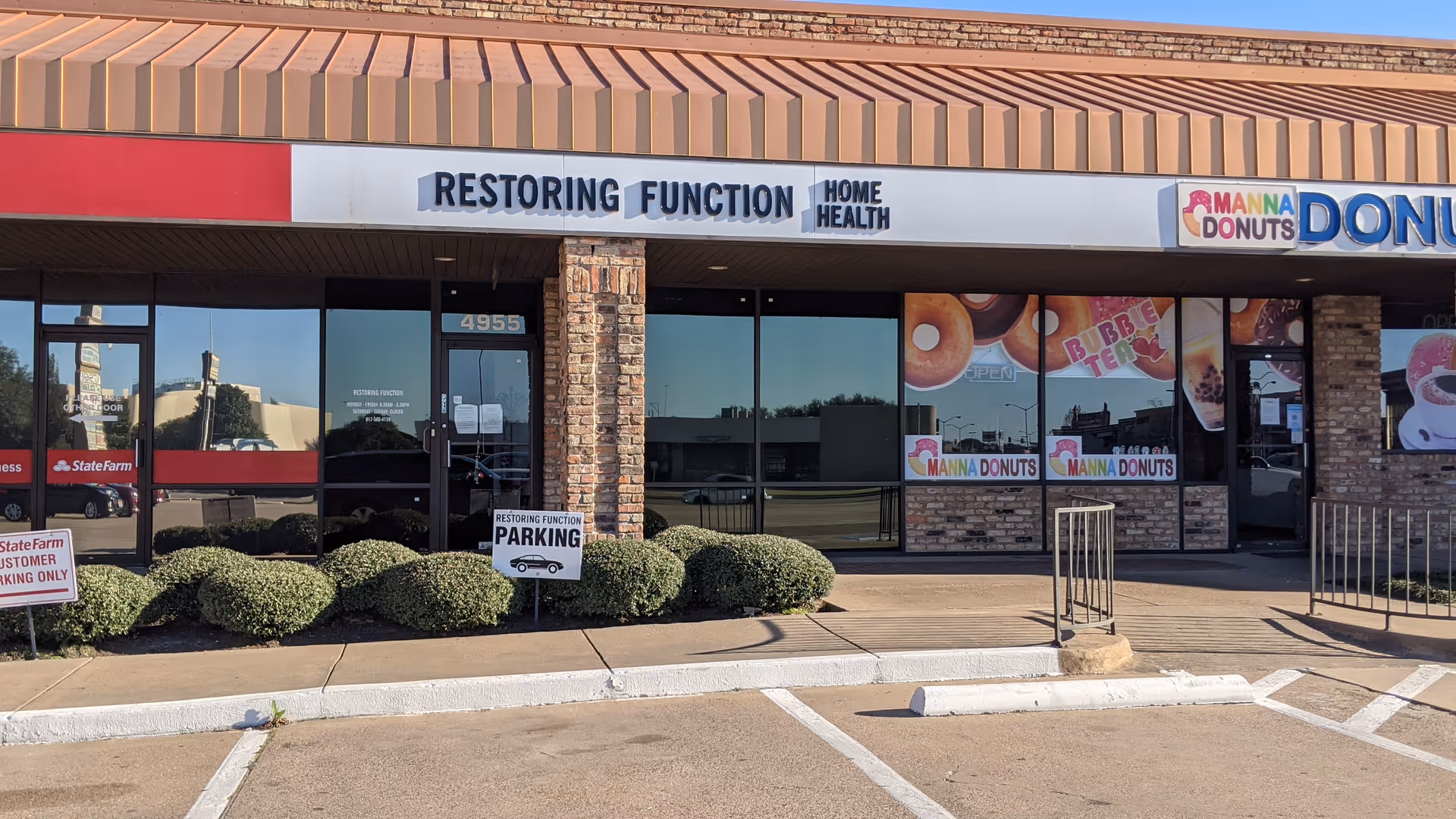 Storefront of Restoring Function Home Health Care with a donut shop beside shrubs.