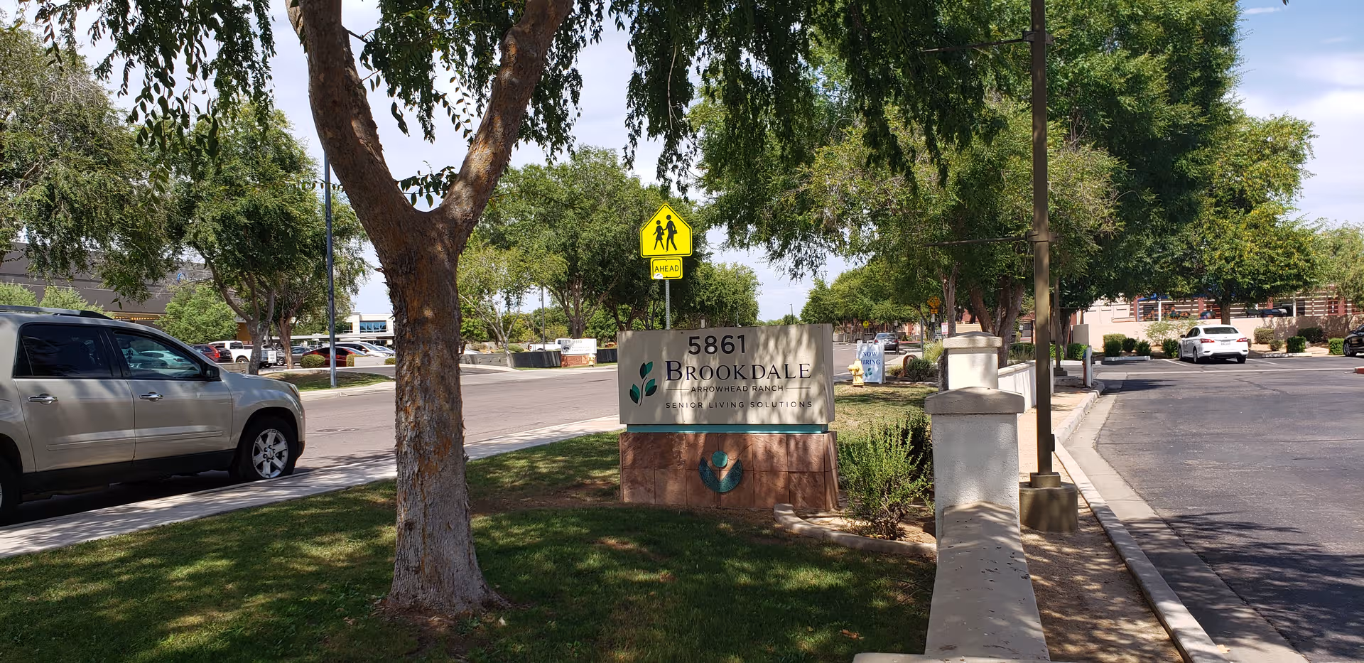 Exterior view of Brookdale Arrowhead Ranch entrance sign with trees and a street.
