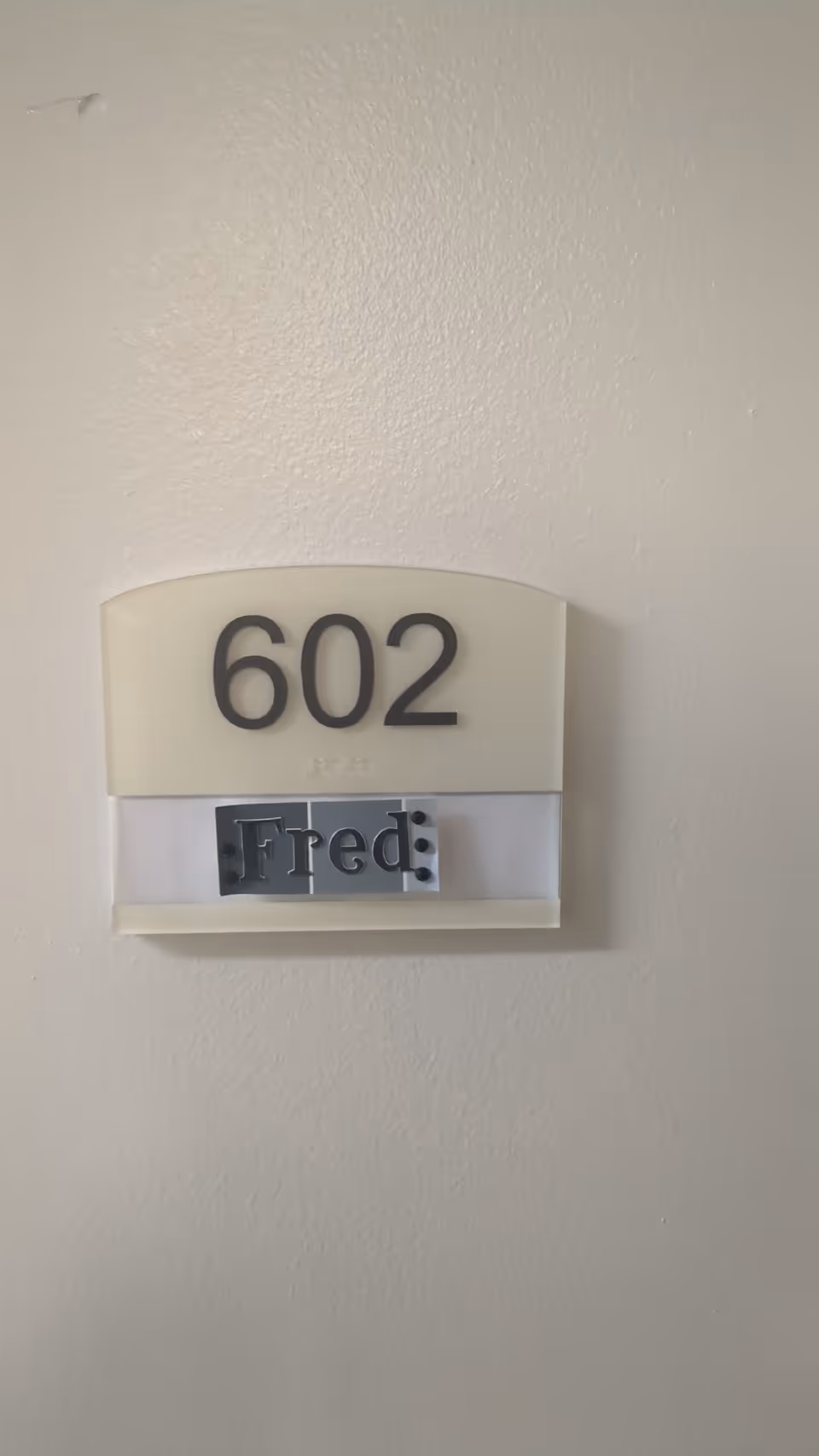 Wall-mounted 602 door plaque with a 'Fred' nameplate.
