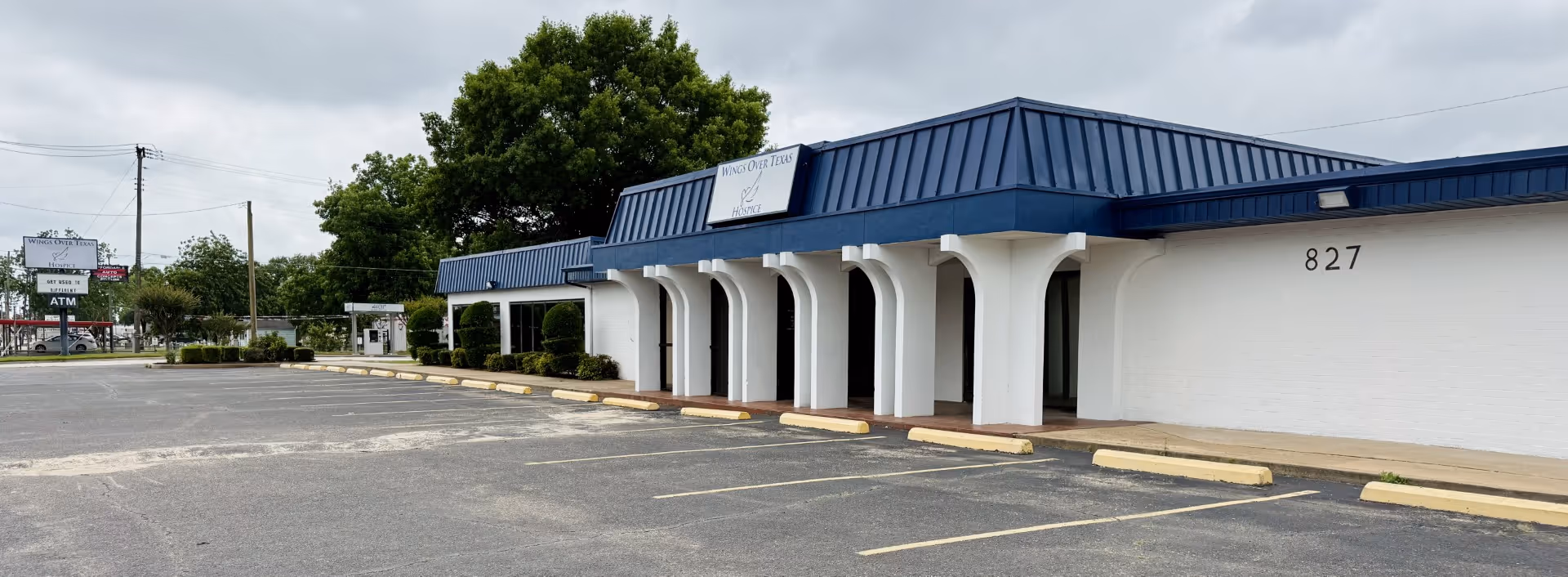 Exterior view of Wings Over Texas Hospice building with blue roof and arches.
