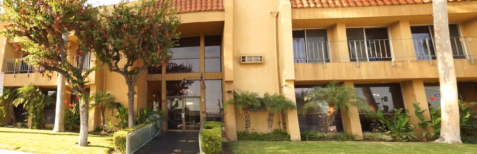 Front view of Regent Villa Retirement Home exterior with tropical landscaping and entry walkway.