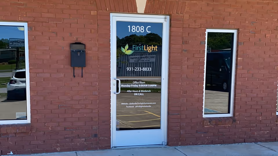 Brick exterior of a building with glass door and FirstLight Home Care sign.