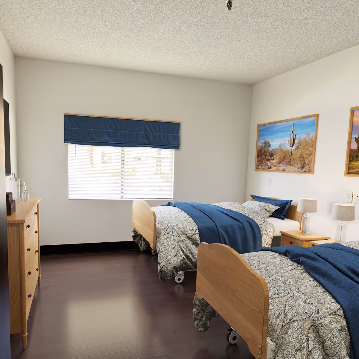 Two twin beds with blue bedspreads in a tidy resident bedroom.