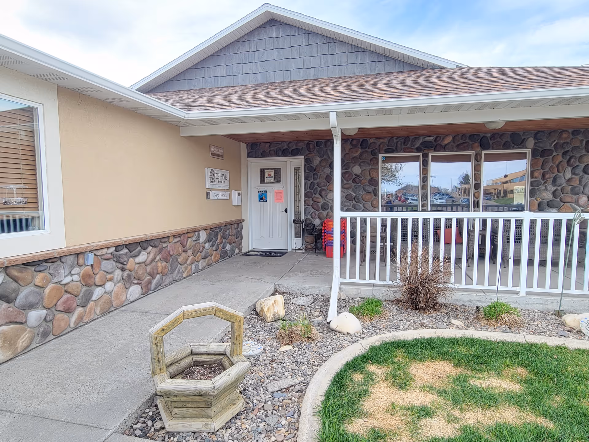 Front exterior of BeeHive Homes of Great Falls with stone facade and porch.