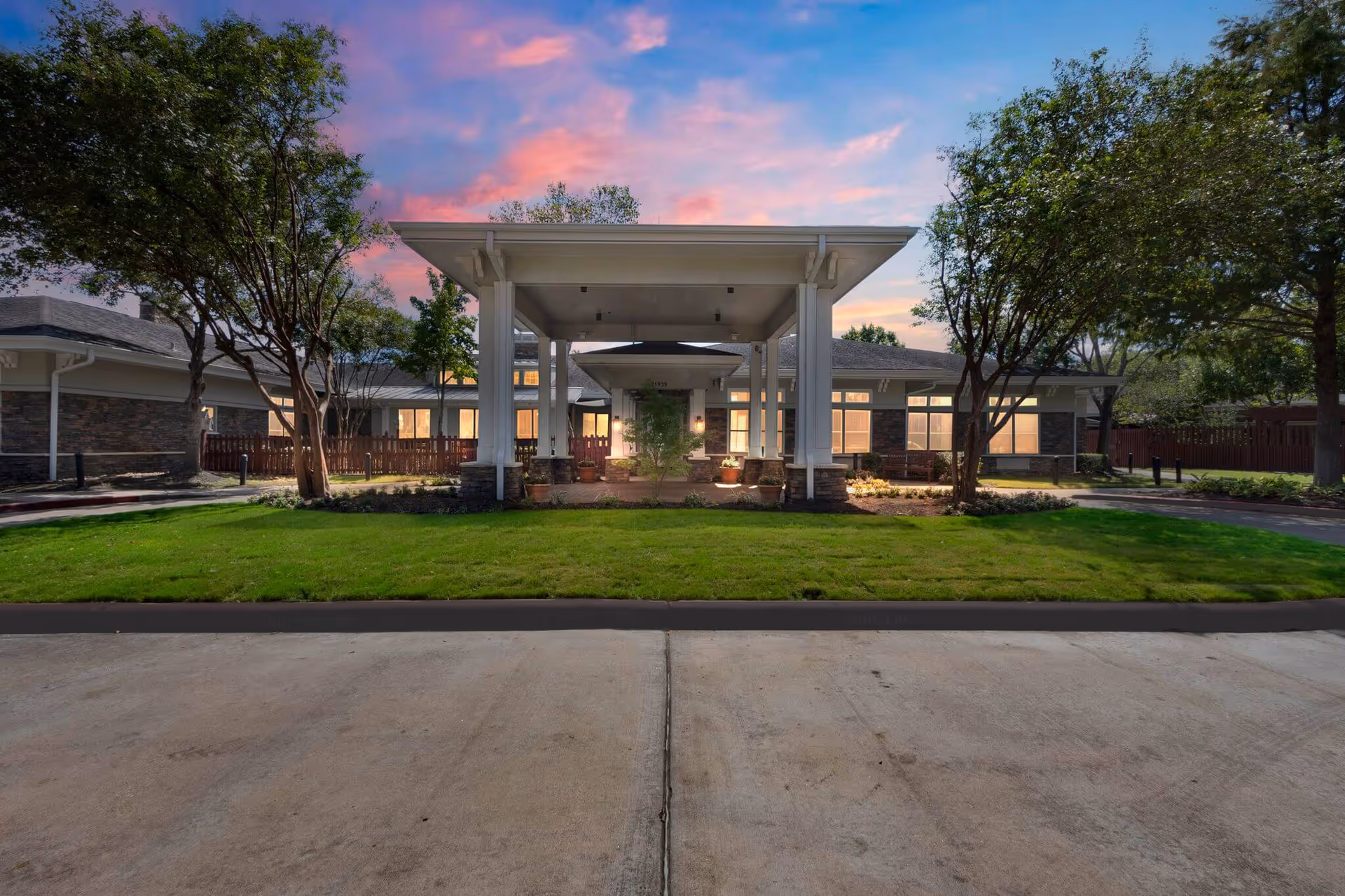 Sunrise of Cinco Ranch exterior entrance with a covered drop-off and manicured lawn.