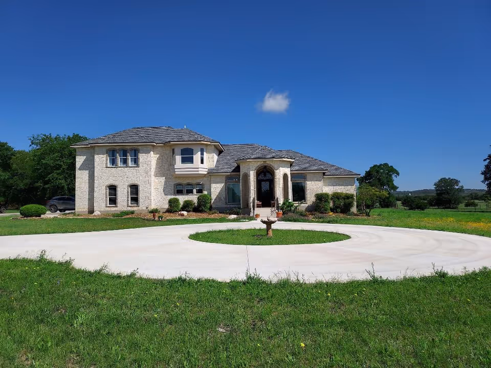 Front view of Hill Country Assisted Living building with circular driveway and lawn.