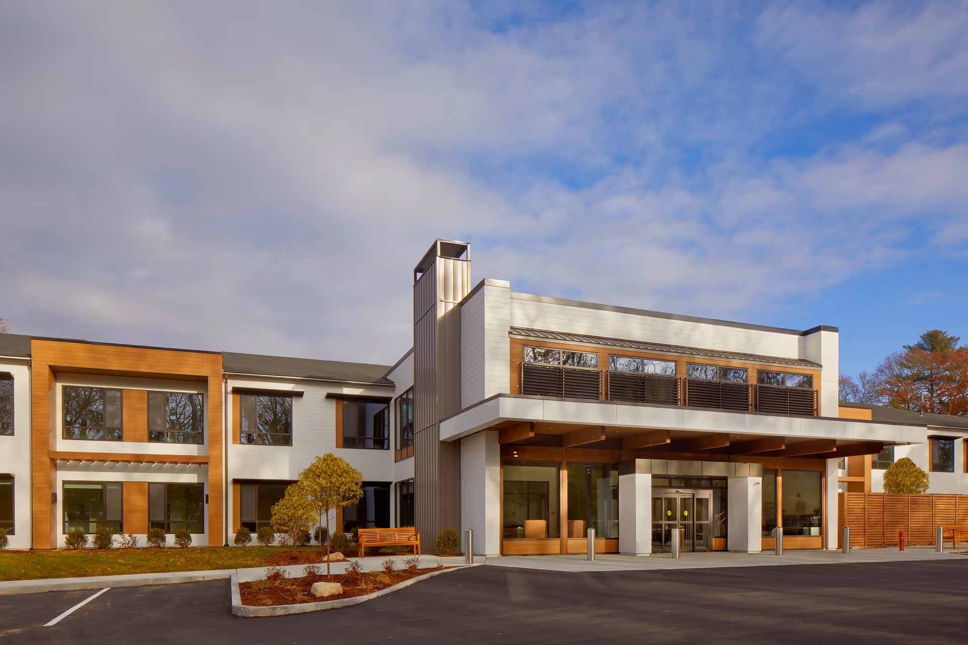 The Cordwainer senior living facility exterior with glass entrance and wooden accents.