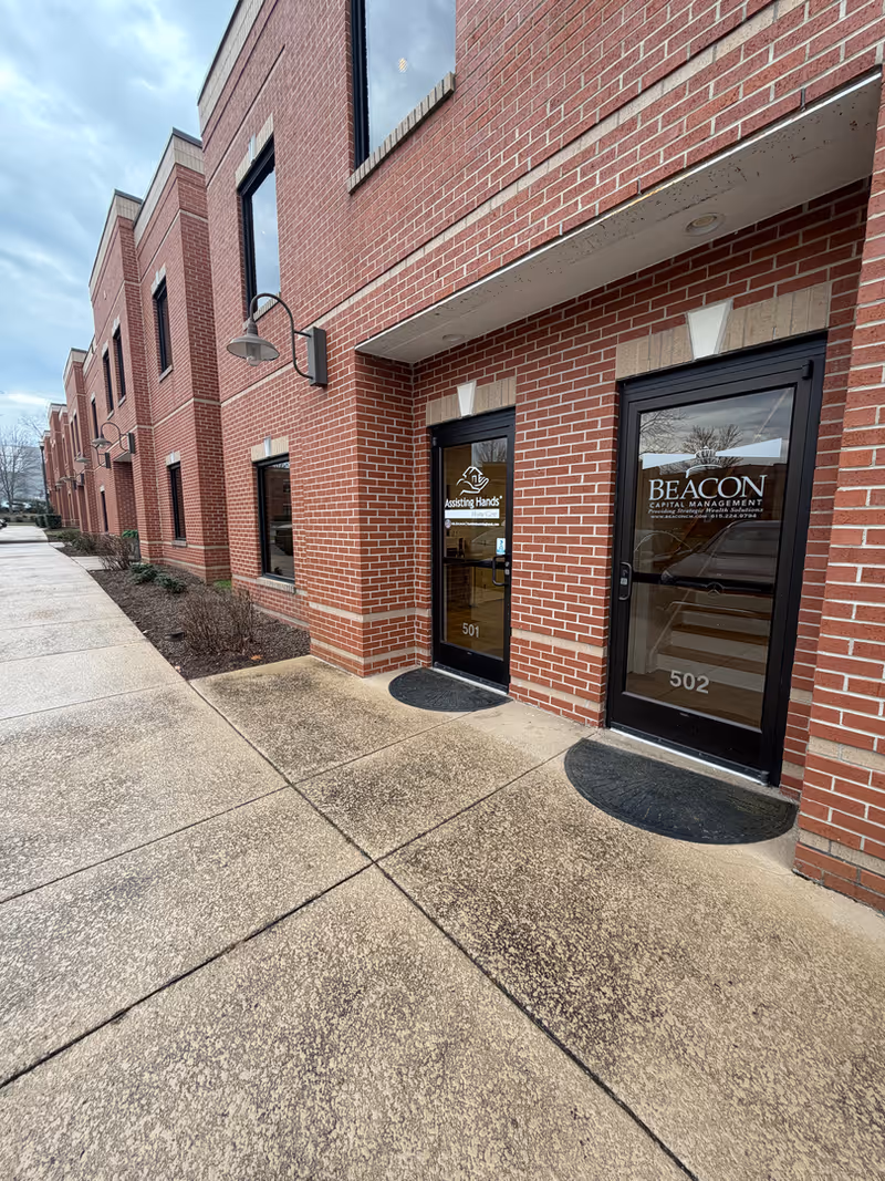Brick exterior of Assisting Hands Home Care entrance with glass doors 501 and 502