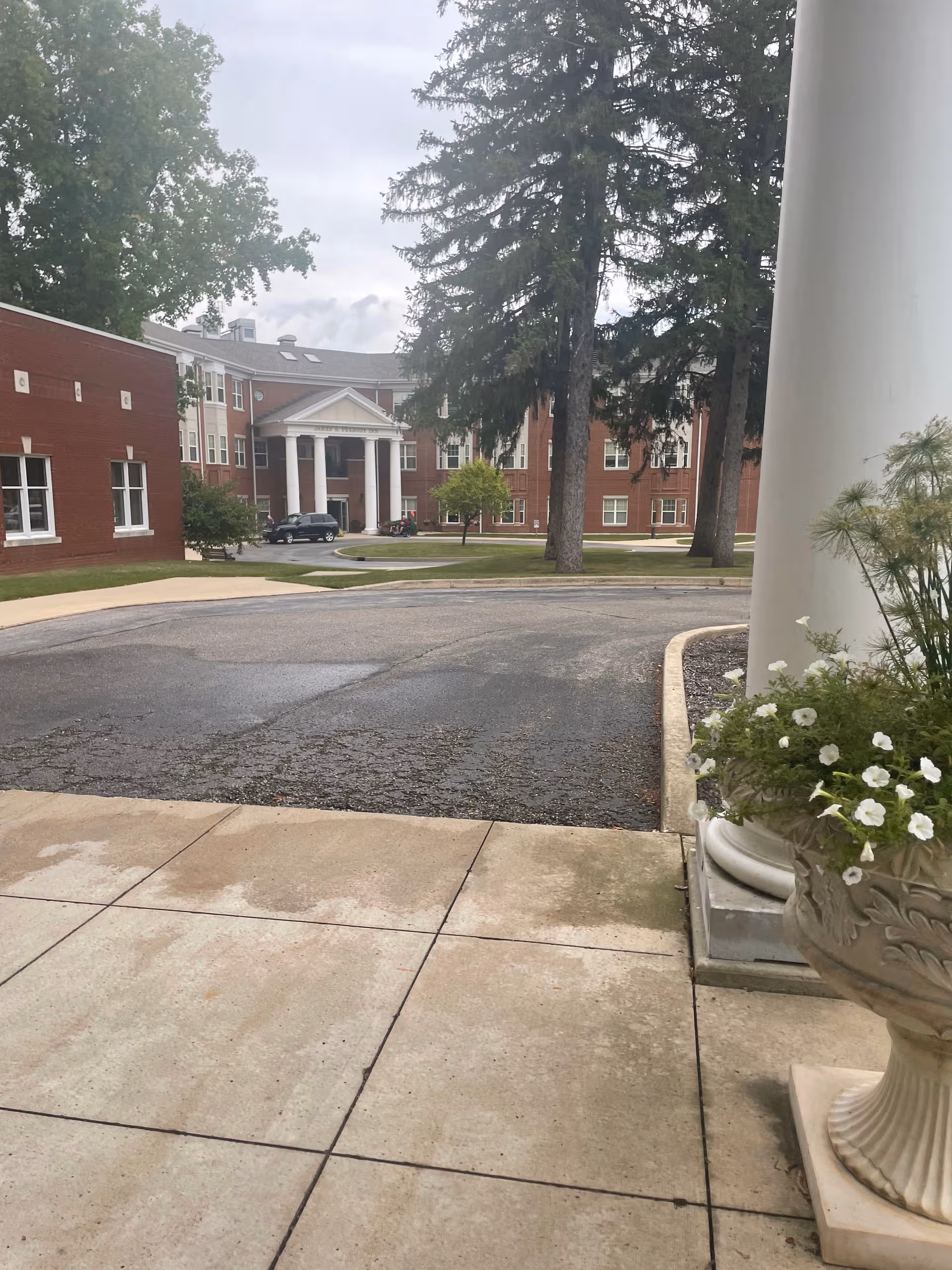 Exterior view of Peabody Retirement Community entrance with white columns and planters.