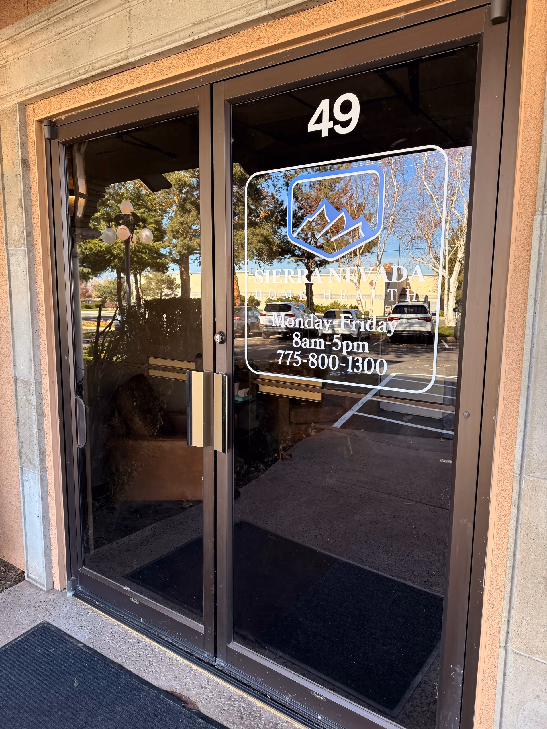 Entrance with glass double doors, building number 49, and Sierra Nevada Home Health logo.
