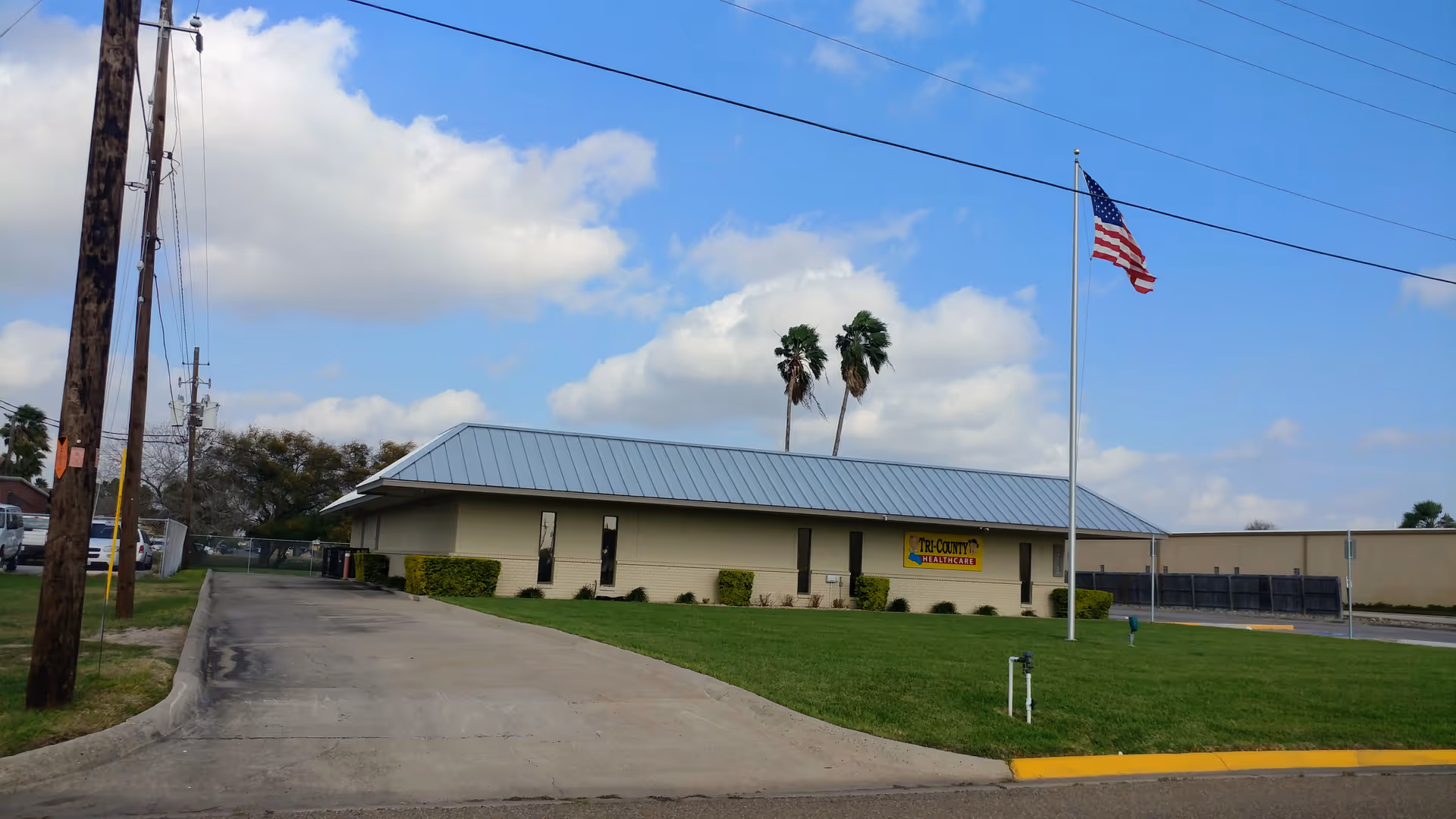 Exterior view of Tri-County Healthcare building with flagpole, lawn, and driveway.