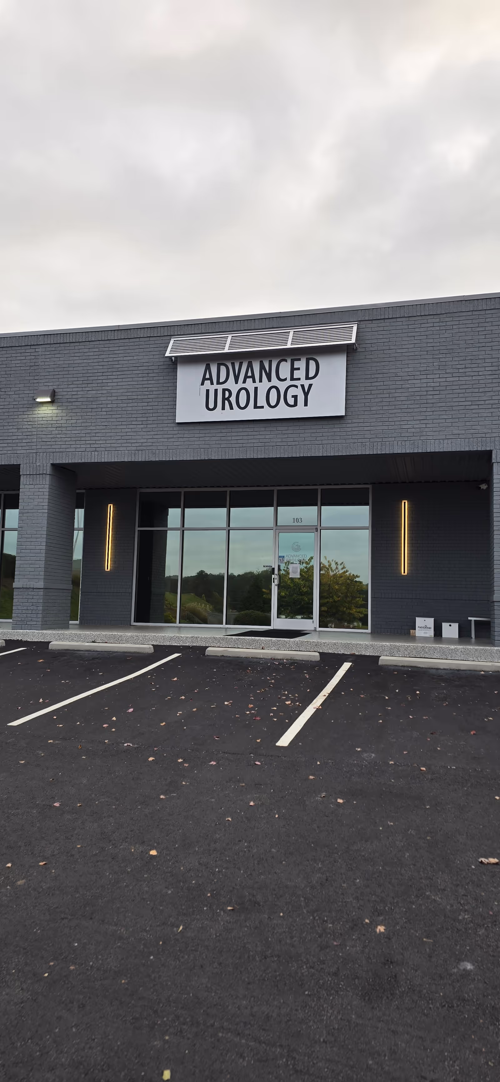 Front exterior of a gray brick medical building with an Advanced Urology sign.