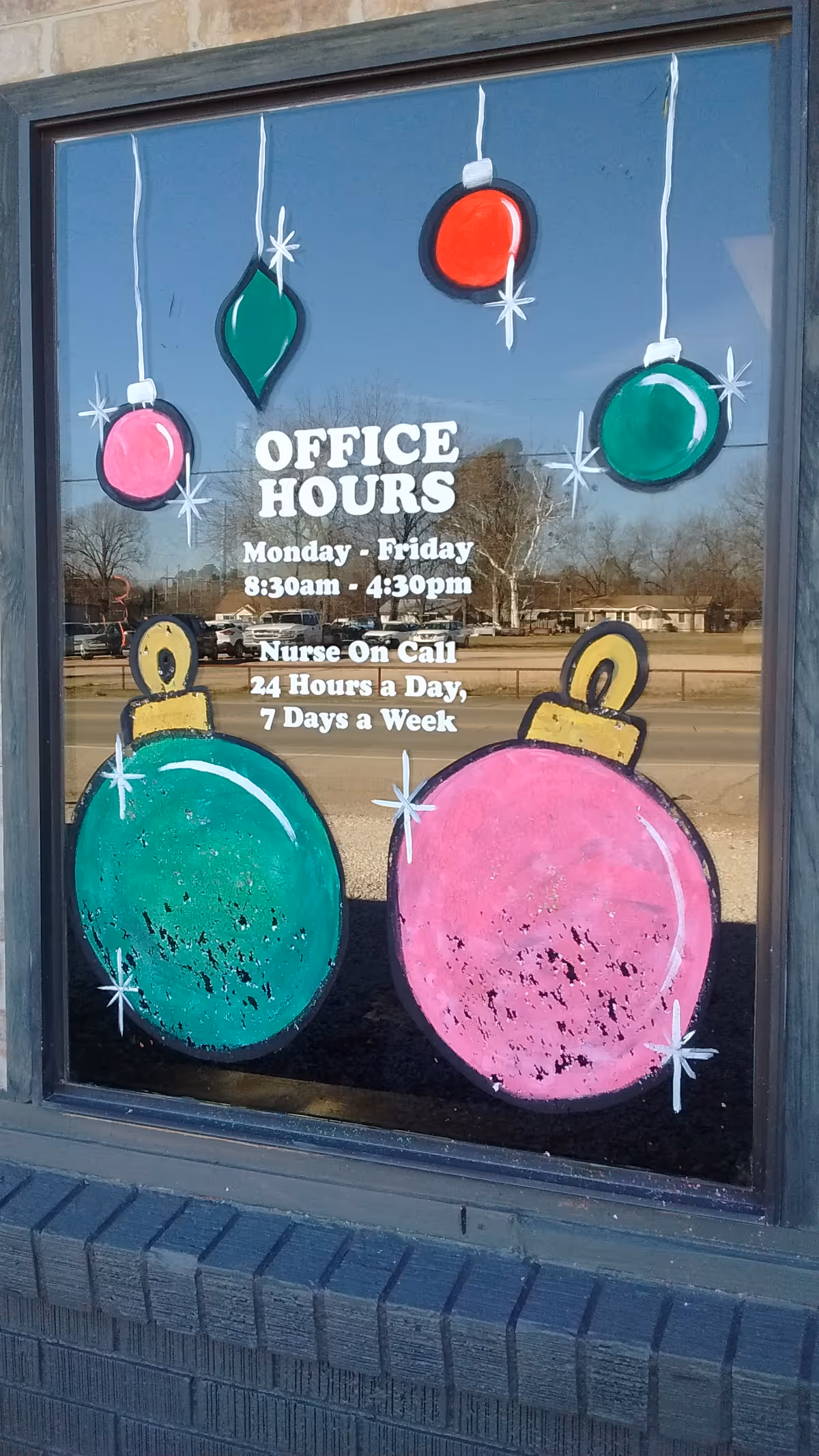 Rainbow Home Health window with colorful hanging ornaments and office hours sign.