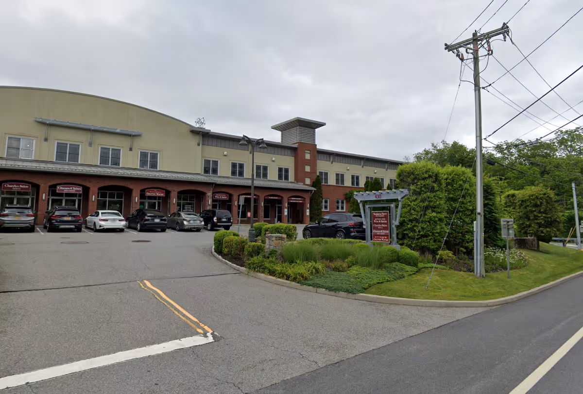 Exterior view of Privatus Care Solutions senior living facility with parked cars at the entrance.