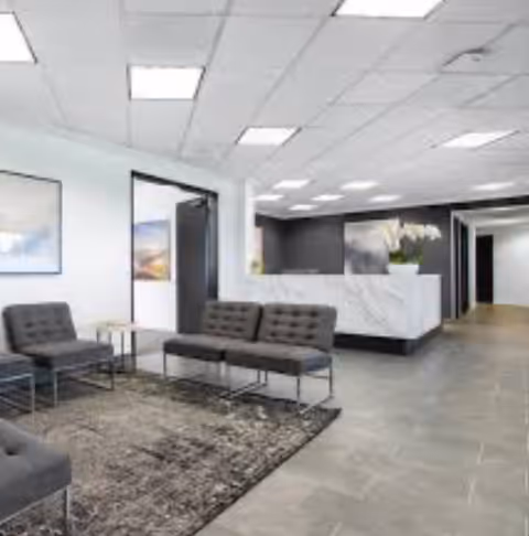 Natt Care LLC lobby area with gray seating and a reception desk.