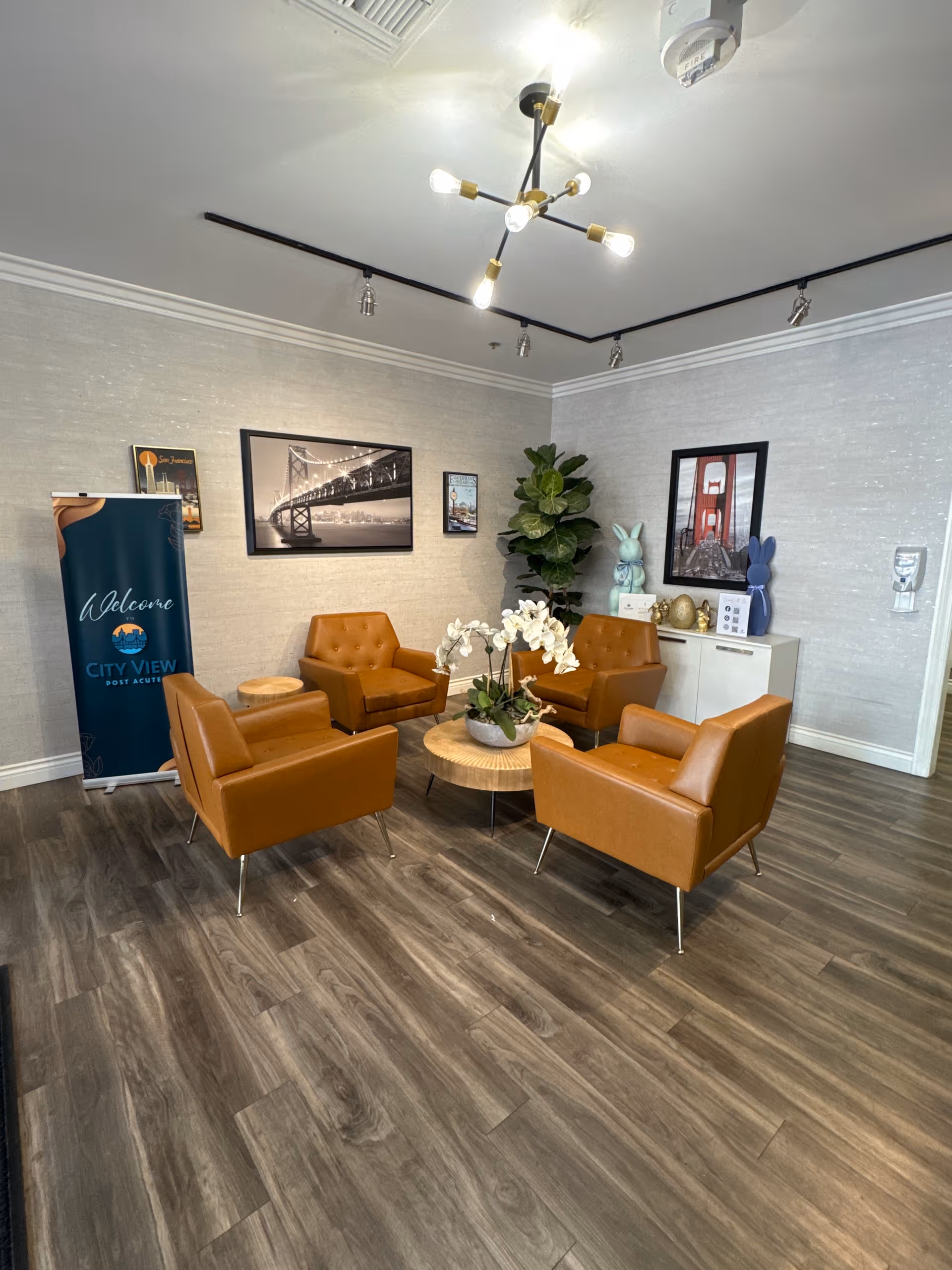 Modern lounge area with orange chairs around a wooden coffee table in a reception-style room.