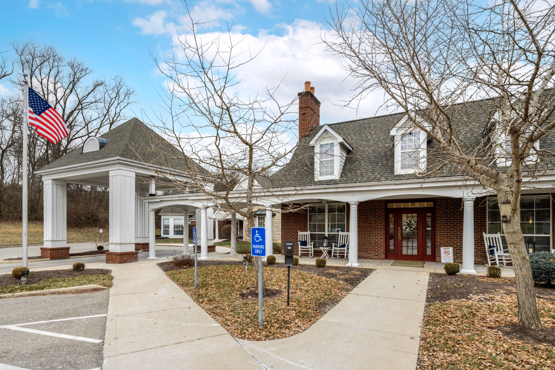 Brookdale Englewood exterior shows brick building, columns, walkway, and an American flag.